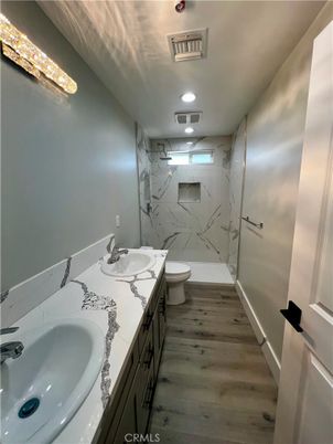 Bathroom, Dual Sink Vanities, Interior, Marble Walls, Recessed Lighting, Wood Texture Flooring