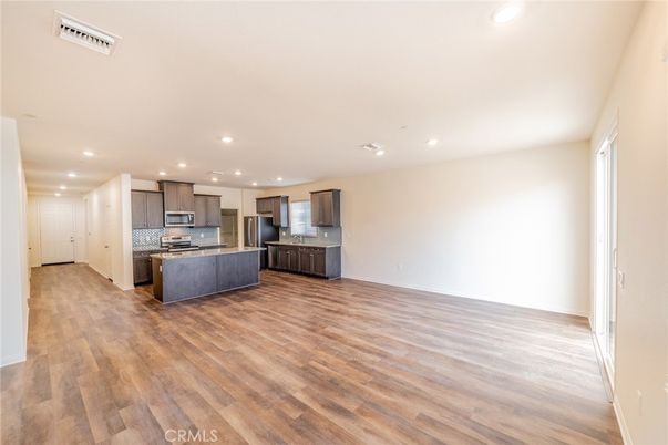 Empty room, Interior, Kitchen, Recessed Lighting, Stainless Steel Appliances, Wood Texture Flooring
