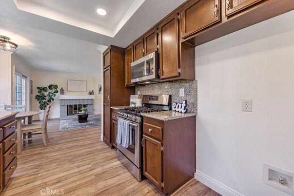Dining room, Fireplace, Interior, Kitchen, Recessed Lighting, Stainless Steel Appliances, Wood Texture Flooring