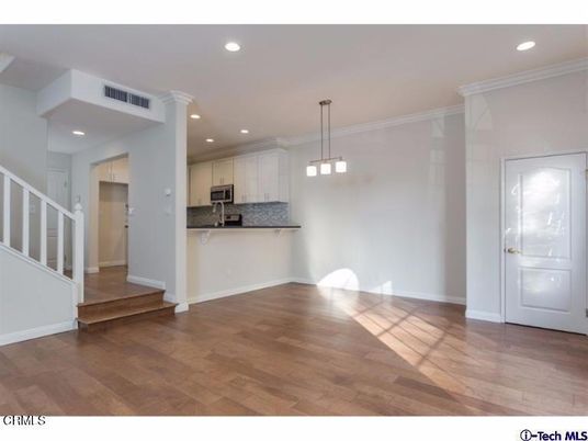 Empty room, Interior, Kitchen, Pendant Lights, Recessed Lighting, Stainless Steel Appliances, Wood Texture Flooring