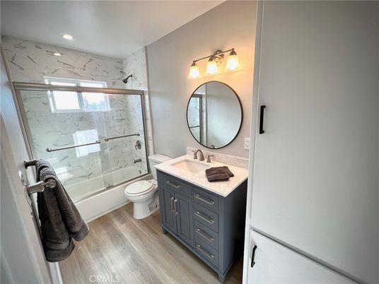 Bathroom, Dual Sink Vanities, Glass Shower, Interior, Marble Walls, Recessed Lighting, Wood Texture Flooring