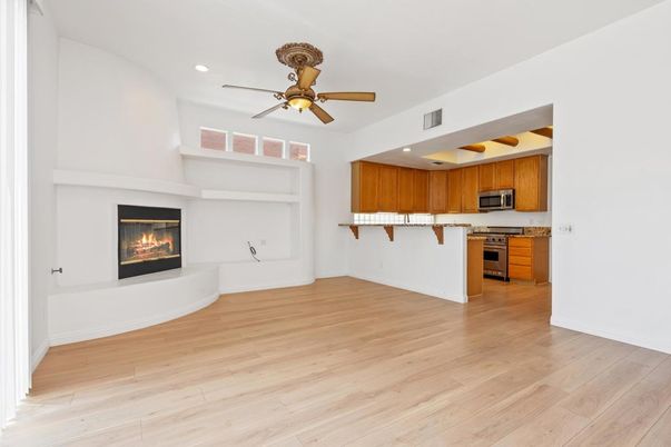 Empty room, Fireplace, Interior, Kitchen, Recessed Lighting, Stainless Steel Appliances, Wood Texture Flooring
