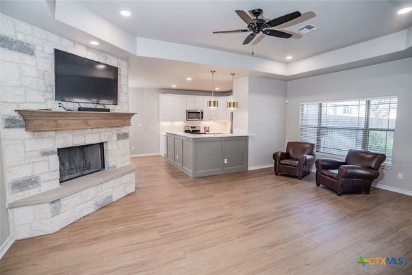 Fireplace, Interior, Kitchen, Pendant Lights, Recessed Lighting, Stainless Steel Appliances, Stone Walls, Wood Texture Flooring