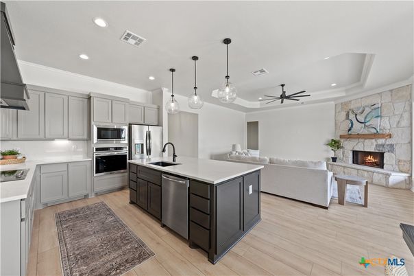 Fireplace, Interior, Kitchen, Living room, Pendant Lights, Recessed Lighting, Stainless Steel Appliances, Stone Walls, Wood Texture Flooring