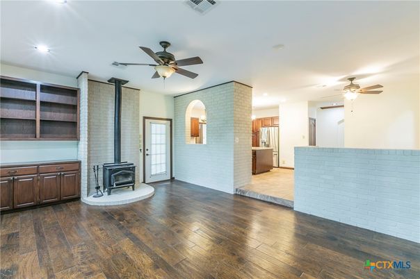 Empty room, Fireplace, Interior, Kitchen, Recessed Lighting, Stone Walls, Wood Texture Flooring