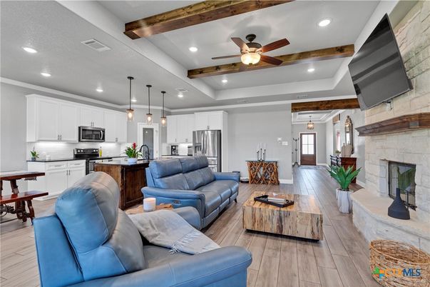 Fireplace, Interior, Kitchen, Living room, Pendant Lights, Recessed Lighting, Stainless Steel Appliances, Stone Walls, Wooden Beams, Wood Texture Flooring