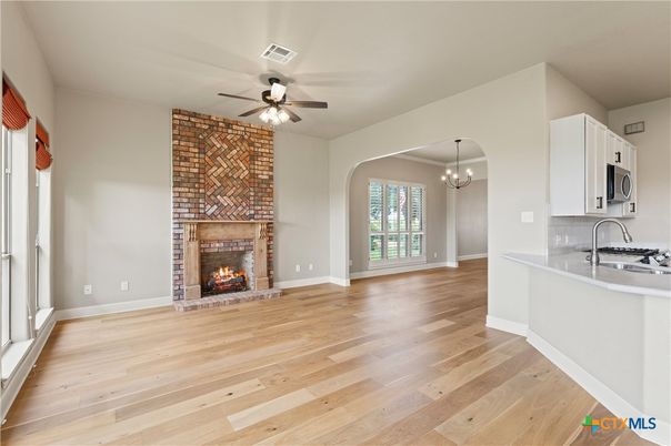 Chandelier, Empty room, Fireplace, Interior, Kitchen, Pendant Lights, Stone Walls, Wood Texture Flooring