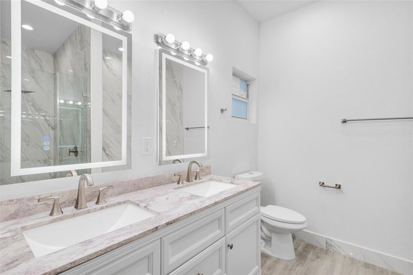 Bathroom, Dual Sink Vanities, Interior, Marble Walls, Recessed Lighting, Wood Texture Flooring