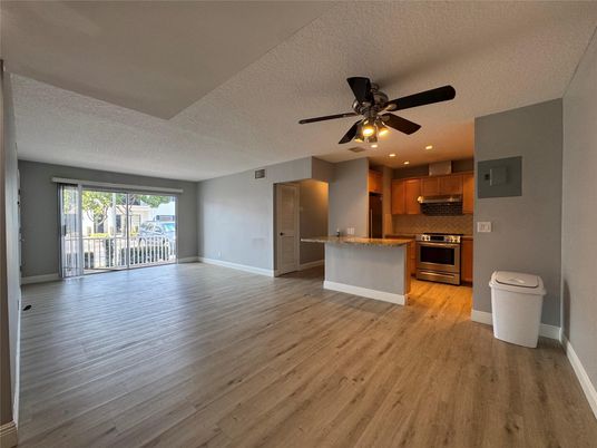 Empty room, Interior, Kitchen, Recessed Lighting, Stainless Steel Appliances, Wood Texture Flooring