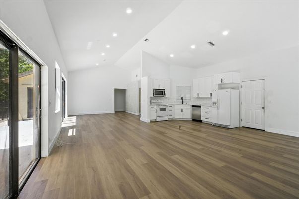 Empty room, Interior, Kitchen, Recessed Lighting, Stainless Steel Appliances, Wood Texture Flooring