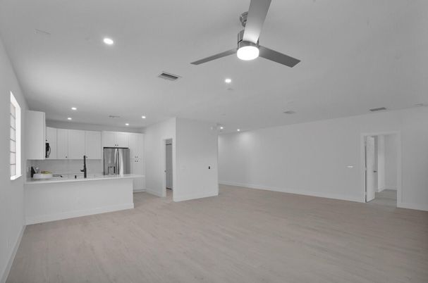 Empty room, Interior, Kitchen, Recessed Lighting, Stainless Steel Appliances, Wood Texture Flooring