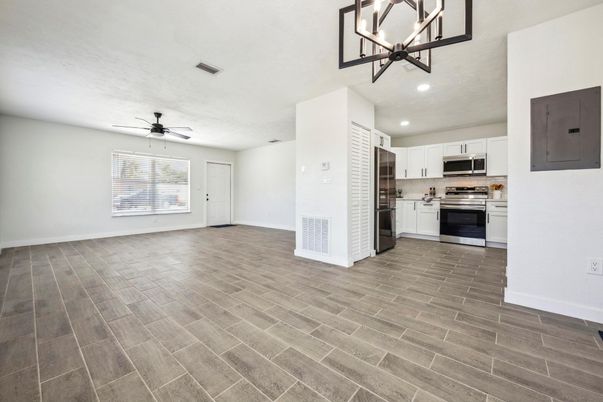 Empty room, Interior, Kitchen, Pendant Lights, Recessed Lighting, Stainless Steel Appliances, Wood Texture Flooring