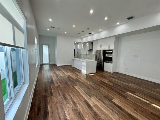 Empty room, Interior, Kitchen, Pendant Lights, Recessed Lighting, Stainless Steel Appliances, Wood Texture Flooring