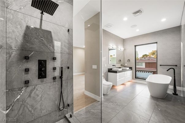 Bathroom, Dual Sink Vanities, Free Standing Baths, Glass Shower, Interior, Marble Walls, Recessed Lighting, Wood Texture Flooring
