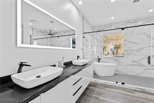 Bathroom, Dual Sink Vanities, Free Standing Baths, Glass Shower, Interior, Marble Walls, Recessed Lighting, Wood Texture Flooring