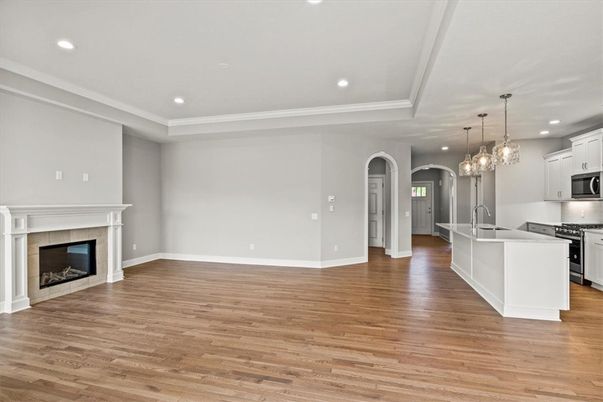 Empty room, Fireplace, Interior, Kitchen, Pendant Lights, Recessed Lighting, Stainless Steel Appliances, Wood Texture Flooring