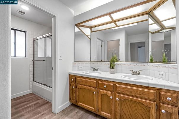 Bathroom, Dual Sink Vanities, Glass Shower, Interior, Recessed Lighting, Tile Countertops, Wood Texture Flooring