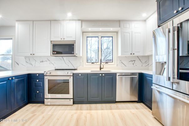 Interior, Kitchen, Marble Walls, Recessed Lighting, Stainless Steel Appliances, Wood Texture Flooring