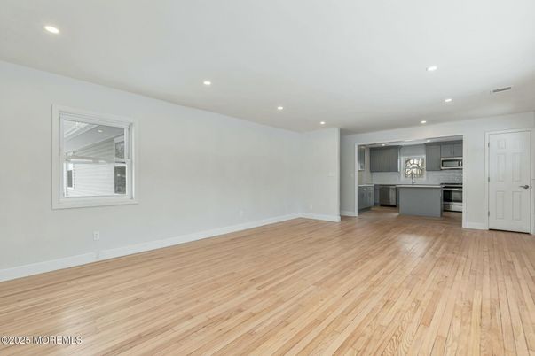 Empty room, Interior, Kitchen, Recessed Lighting, Stainless Steel Appliances, Wood Texture Flooring