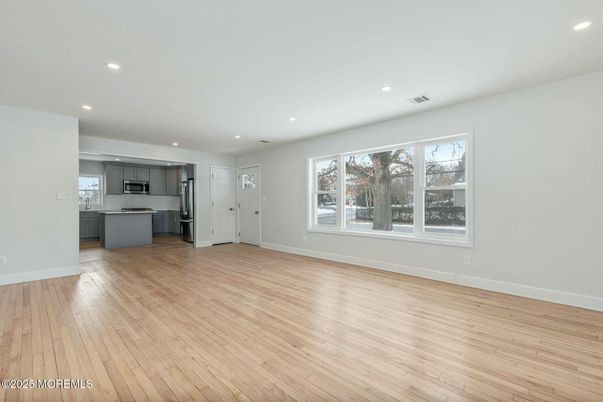Empty room, Interior, Kitchen, Recessed Lighting, Stainless Steel Appliances, Wood Texture Flooring