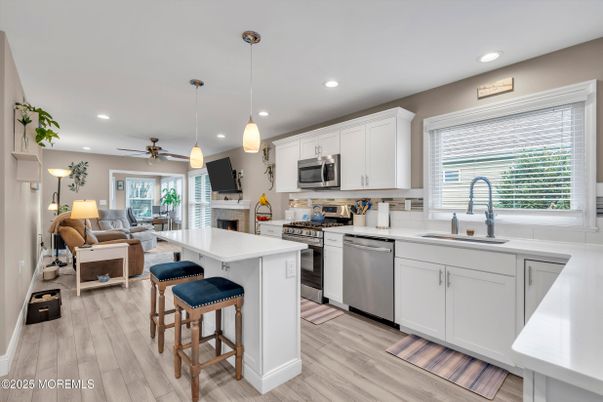 Fireplace, Interior, Kitchen, Living room, Pendant Lights, Recessed Lighting, Stainless Steel Appliances, Wood Texture Flooring