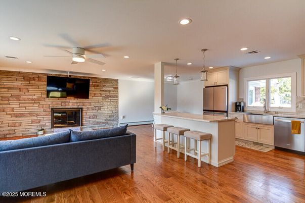 Fireplace, Interior, Kitchen, Living room, Pendant Lights, Recessed Lighting, Stainless Steel Appliances, Stone Walls, Wood Texture Flooring