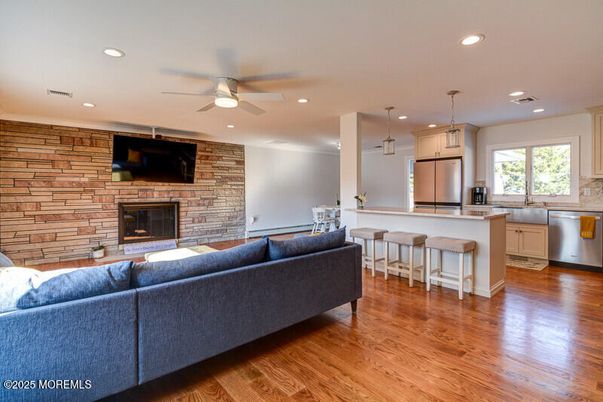 Fireplace, Interior, Kitchen, Living room, Pendant Lights, Recessed Lighting, Stainless Steel Appliances, Stone Walls, Wood Texture Flooring