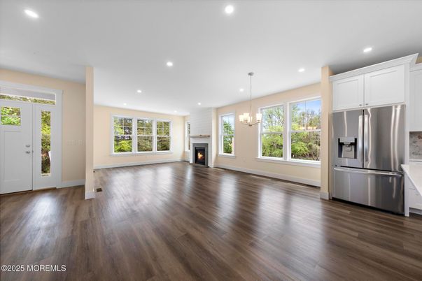 Chandelier, Empty room, Fireplace, Interior, Kitchen, Pendant Lights, Recessed Lighting, Stainless Steel Appliances, Wood Texture Flooring