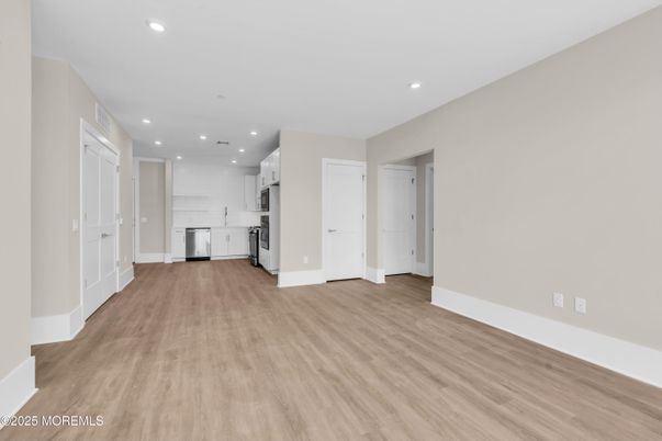 Empty room, Interior, Kitchen, Recessed Lighting, Stainless Steel Appliances, Wood Texture Flooring