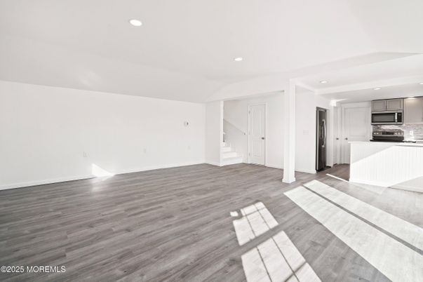 Empty room, Interior, Kitchen, Recessed Lighting, Stainless Steel Appliances, Wood Texture Flooring