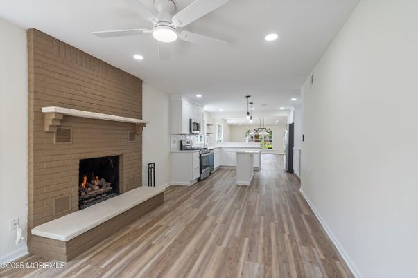 Fireplace, Interior, Kitchen, Pendant Lights, Recessed Lighting, Stainless Steel Appliances, Stone Walls, Wood Texture Flooring