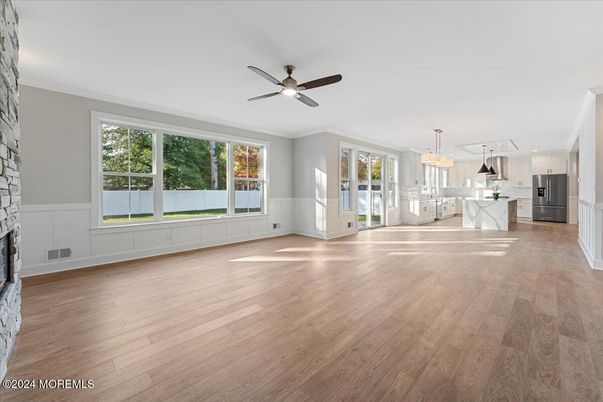 Chandelier, Empty room, Fireplace, Interior, Kitchen, Pendant Lights, Stainless Steel Appliances, Wood Texture Flooring