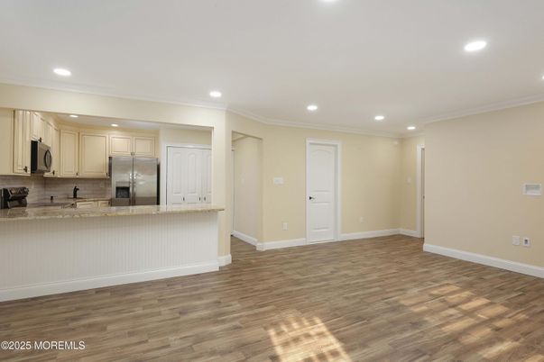 Empty room, Interior, Kitchen, Recessed Lighting, Stainless Steel Appliances, Wood Texture Flooring