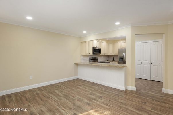 Empty room, Interior, Kitchen, Recessed Lighting, Stainless Steel Appliances, Wood Texture Flooring
