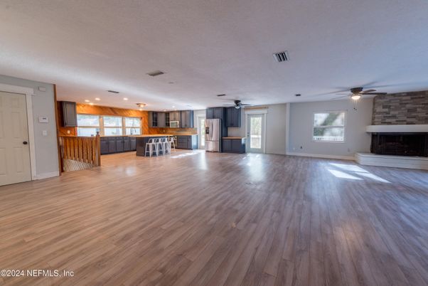 Empty room, Fireplace, Interior, Kitchen, Recessed Lighting, Stone Walls, Wood Texture Flooring