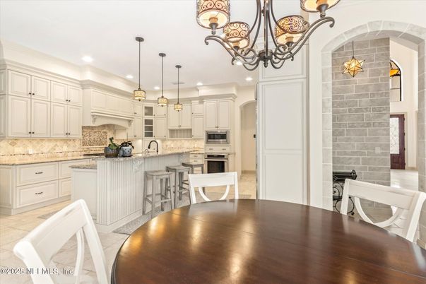 Chandelier, Dining room, Interior, Kitchen, Pendant Lights, Recessed Lighting, Stainless Steel Appliances, Stone Walls, Wood Texture Flooring