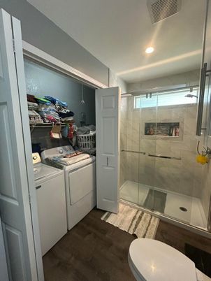 Bathroom, Glass Shower, Interior, Recessed Lighting, Washer, Wood Texture Flooring