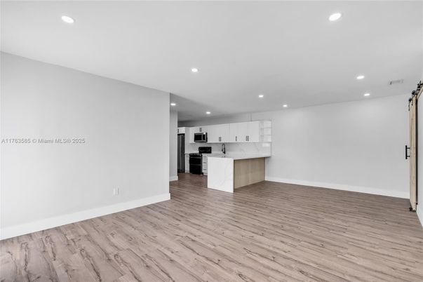 Empty room, Interior, Kitchen, Recessed Lighting, Stainless Steel Appliances, Wood Texture Flooring