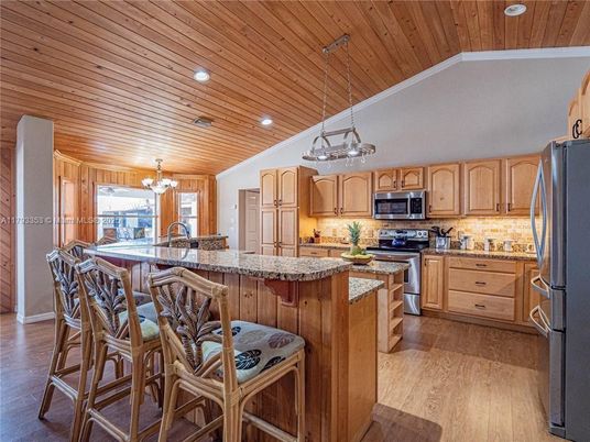 Chandelier, Dining room, Interior, Kitchen, Pendant Lights, Recessed Lighting, Stainless Steel Appliances, Wooden Ceilings, Wood Texture Flooring