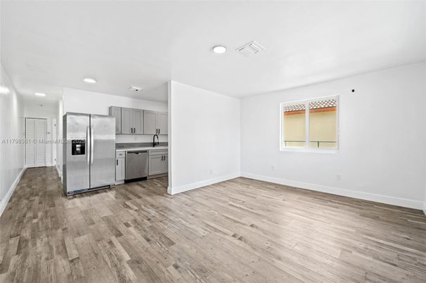 Empty room, Interior, Kitchen, Recessed Lighting, Stainless Steel Appliances, Wood Texture Flooring