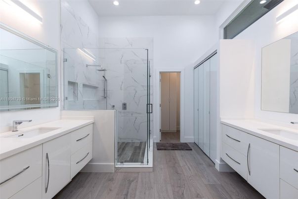 Bathroom, Dual Sink Vanities, Glass Shower, Interior, Marble Walls, Recessed Lighting, Wood Texture Flooring