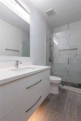 Bathroom, Dual Sink Vanities, Glass Shower, Interior, Marble Walls, Wood Texture Flooring