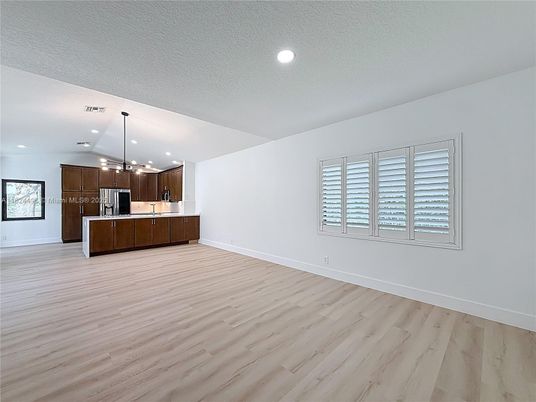 Empty room, Interior, Kitchen, Pendant Lights, Recessed Lighting, Stainless Steel Appliances, Wood Texture Flooring