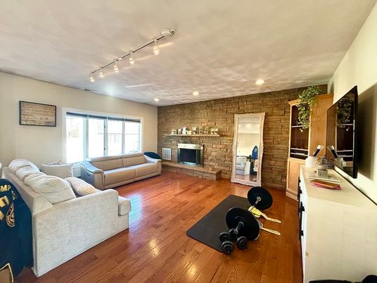 Fireplace, Fitness Equipment, Interior, Living room, Recessed Lighting, Stone Walls, Wood Texture Flooring