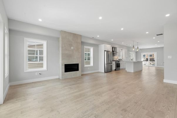 Chandelier, Empty room, Fireplace, Interior, Kitchen, Pendant Lights, Recessed Lighting, Stainless Steel Appliances, Wood Texture Flooring