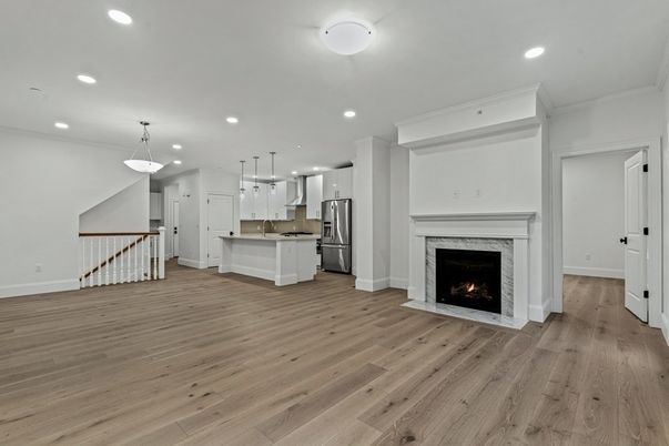 Empty room, Fireplace, Interior, Kitchen, Pendant Lights, Recessed Lighting, Stainless Steel Appliances, Wood Texture Flooring