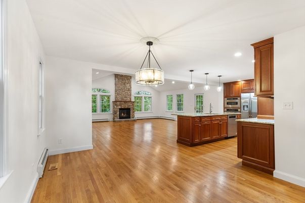 Empty room, Fireplace, Interior, Kitchen, Pendant Lights, Recessed Lighting, Stainless Steel Appliances, Wood Texture Flooring