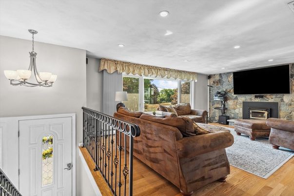 Chandelier, Fireplace, Interior, Living room, Recessed Lighting, Stone Walls, Wood Texture Flooring