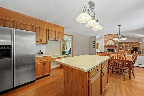 Dining room, Fireplace, Interior, Kitchen, Pendant Lights, Stainless Steel Appliances, Stone Walls, Wood Texture Flooring