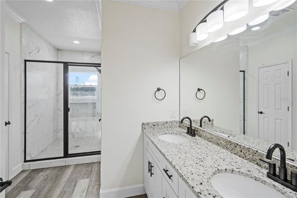 Bathroom, Dual Sink Vanities, Glass Shower, Interior, Marble Walls, Recessed Lighting, Wood Texture Flooring